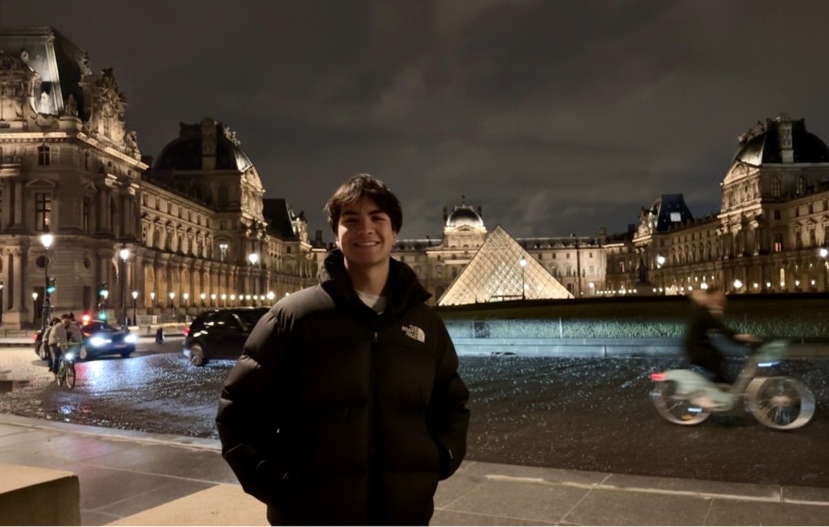 Caleb at night in front of the Louvre pyramid in Paris
